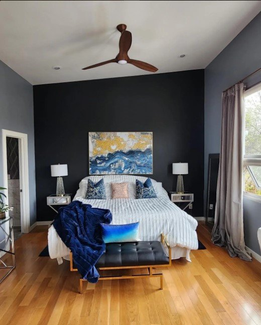 Bedroom with a navy accent wall behind the bed and gray side walls
